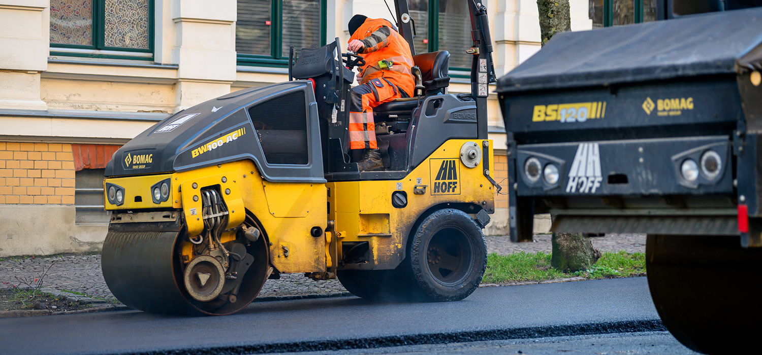 Dynamischer Einsatz einer Straßenwalze auf einer Großbaustelle – ausdrucksstarke Baustellenfotos zur Dokumentation von Infrastrukturprojekten.